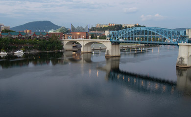 Naklejka premium Blue bridge across a river at sunrise, leading to downtown Chattanooga, Tennessee