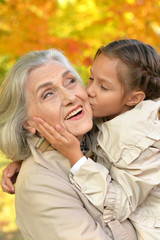 portrait of happy grandmother and granddaughter in park