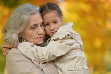 portrait of happy grandmother and granddaughter in park