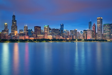 Naklejka na ściany i meble Chicago downtown skyline taken in a fantastic cloudy evening, with lights of the skyscrapers reflected in lake Michigan, Illinois, United States