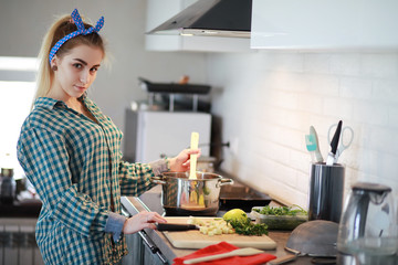A cute young girl in the kitchen prepares food