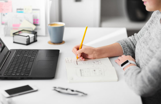 app design, technology and business concept - web designer or developer working on user interface and drawing sketches at office