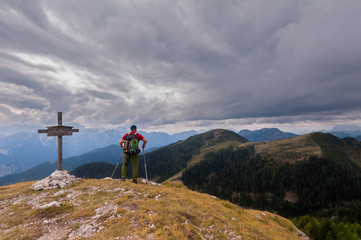 Hiker with backpack standing on top of a mountain