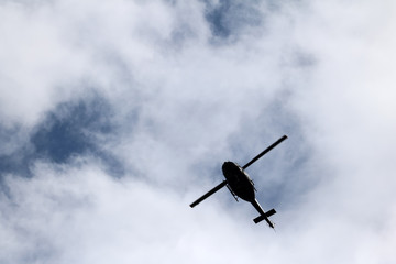 black helicopter aircraft during the flight with blue sky