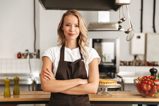Smiling young woman chef cook in apron
