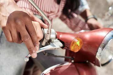 Romantic Relationship. Young diverse couple riding bike on the city street together close-up. Man teaching woman to ride