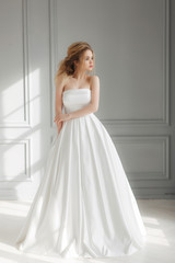 Fototapeta na wymiar beautiful bride in simple luxurious wedding dress looking left side