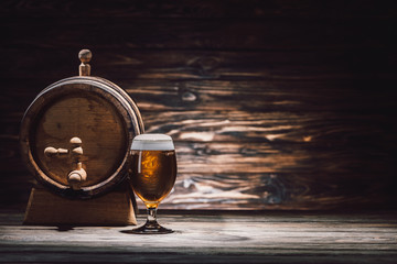 glass of beer and beer barrel on wooden table, oktoberfest concept