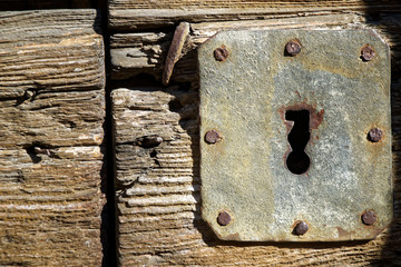 Rustic door knob and keyhole on the old wooden door, Vintage style.