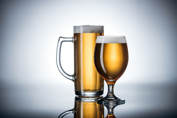 two glasses of tasty beer on reflecting surface, oktoberfest concept