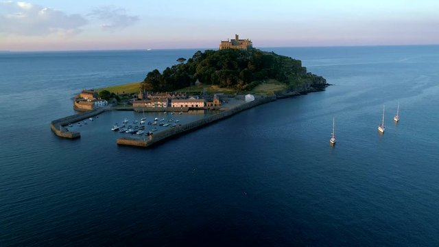 Drone descends slowly by St Michaels Mount Cornwall with yachts in foreground