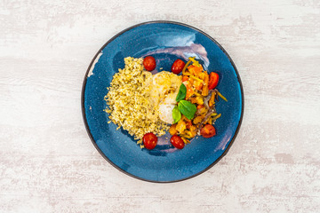 Cooked rice with vegetables, cod and lemon sauce