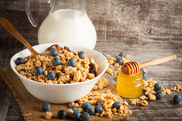 Healthy breakfast concept with oat flakes and fresh berries on rustic background. Food made of granola and muesli. Healthy banana smoothie with blackberries, honey and milk.