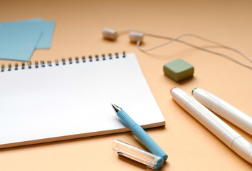 The stationery and headphones on a orange background.