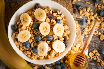 Healthy breakfast concept with oat flakes and fresh berries on rustic background. Food made of granola and muesli. Healthy banana smoothie with blackberries, honey and milk.