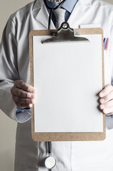 Doctor (model) holding Clipboard with Blank Sheet of Paper Facing Viewer
