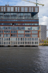 Naklejka premium View on the Amsterdam residential area from the Amstel river in a cloudy day