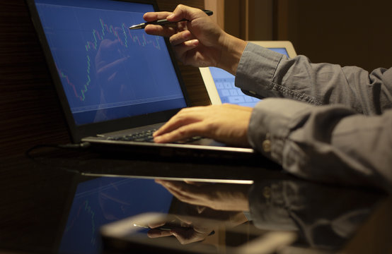 trader use finger interest chart candlesitck data at monitor computer in forex market stock, finance concept.