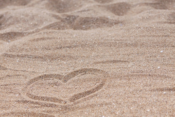 Fototapeta na wymiar Photo of a sandy beach with a drawn heart