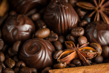 Assortment of white, dark, and milk chocolate. Chocolate with cream, nuts, almonds, hazelnuts and cinnamon with coffee beans. Sweet food and no diet concept.