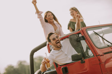 Happy friends having fun in convertible car at vacation