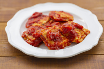 Ravioli with tomato sauce on a white plate