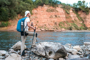 Hiker with blue backpack admires the nature