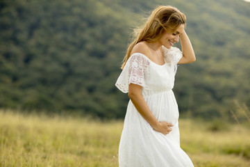 Young pregnant woman relaxing outside in nature