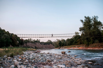 Traveller walks the bridge over river