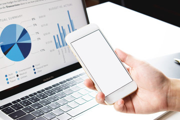Side view of a business girl holding a phone and looking at the screen with a diagram.