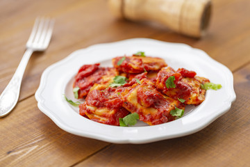 Ravioli with tomato sauce on a white plate