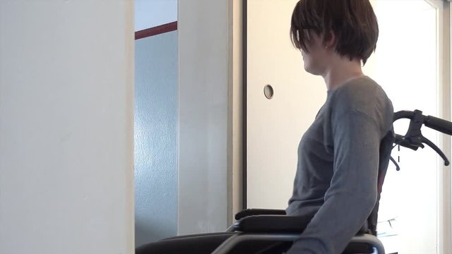Disabled woman in wheelchair at home