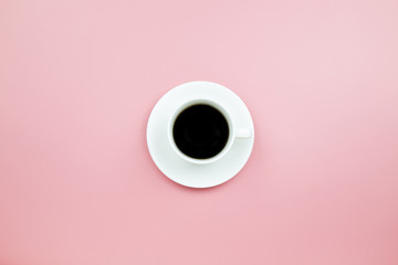 Black coffee in white cup on pink blackground pastel style copyspace flatlay topview.