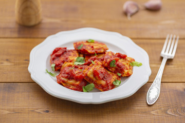 Ravioli with tomato sauce on a white plate