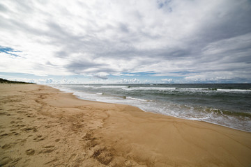 Sand beach and sea waves, Baltic sea seashore during sunset. Curonian spit, Kaliningrad region, Russia