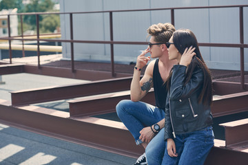 young handsome man smoking cigarette near his girlfriend