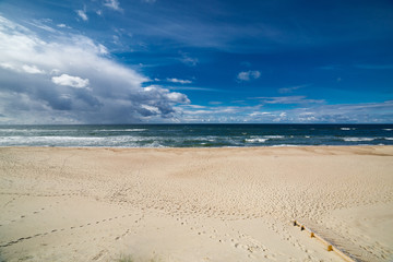 Sand beach and sea waves, Baltic sea seashore during sunset. Curonian spit, Kaliningrad region, Russia