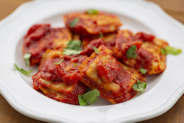Ravioli with tomato sauce on a white plate