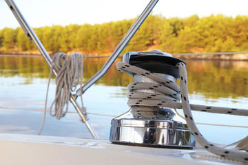 A winch on a sailing yacht for pulling up files and sheets against the background of the summer...