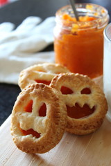 Homemade pumpkin cookie on funny faces for Halloween. Autumn snak.