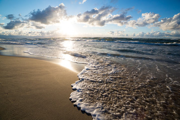 Sand beach and sea waves, Baltic sea seashore during sunset. Curonian spit, Kaliningrad region, Russia