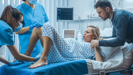 In the Hospital, Woman in Labor Gives Birth, Obstetricians and Doctors Assist, Her Husband Supports...