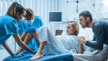 In the Hospital, Woman in Labor Gives Birth, Obstetricians and Doctors Assist, Her Husband Supports...