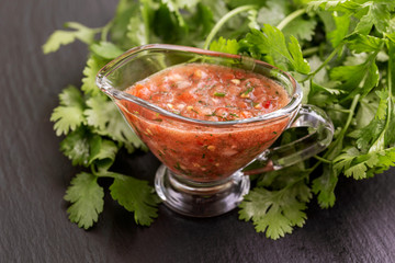 Traditional mexican red spicy sauce salsa with cilantro