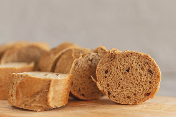 Fresh sliced rye baguette on the wooden cutting board