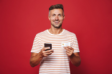 Portrait of a cheerful man standing over red background