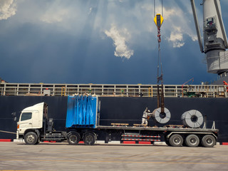 The vessel discharging steel coils on truck at industrial port of thailand