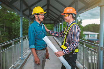 engineers stand hand in hand on bridge