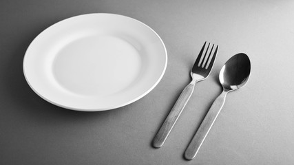 fork, spoon and a white ceramic dish