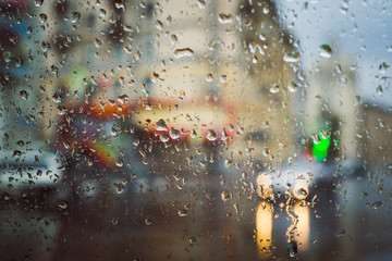 City road seen through rain drops on the car windshield